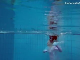 Pelirroja simonna que muestra su cuerpo bajo el agua